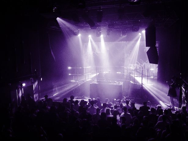 Vue de la salle pendant un DJ set Rave Records, faisceaux lumineux au‑dessus du public